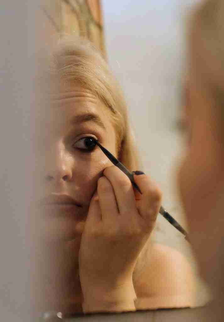 young lady applying eyeliner