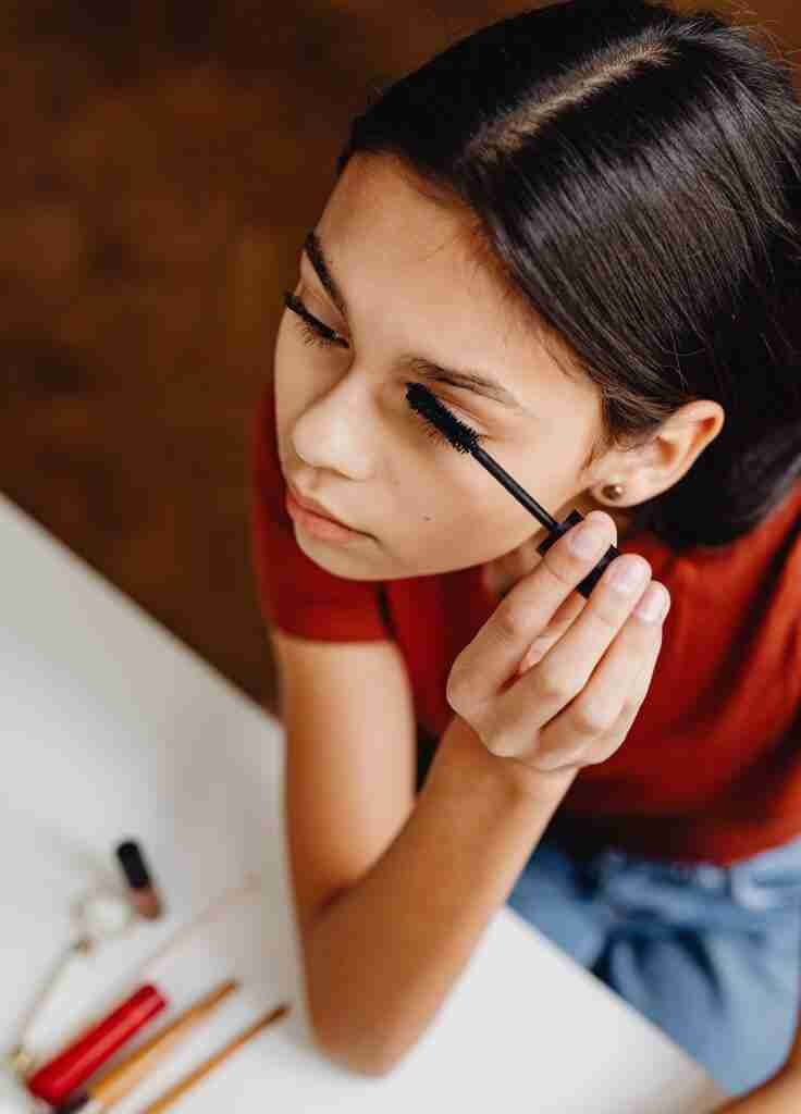 young lady applying mascara