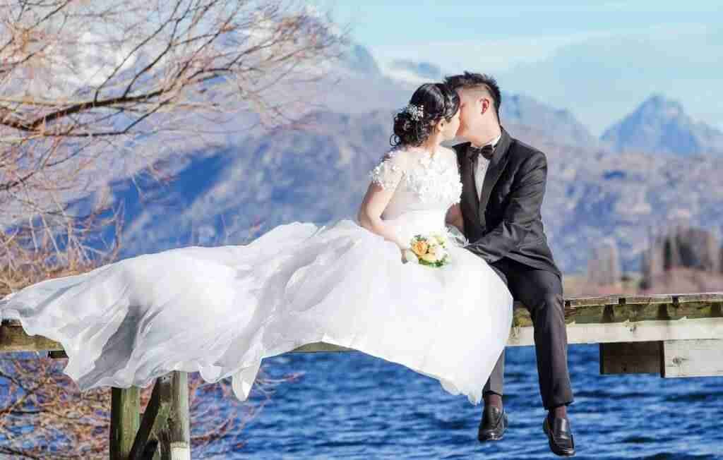 wedding couple kissing by a lake