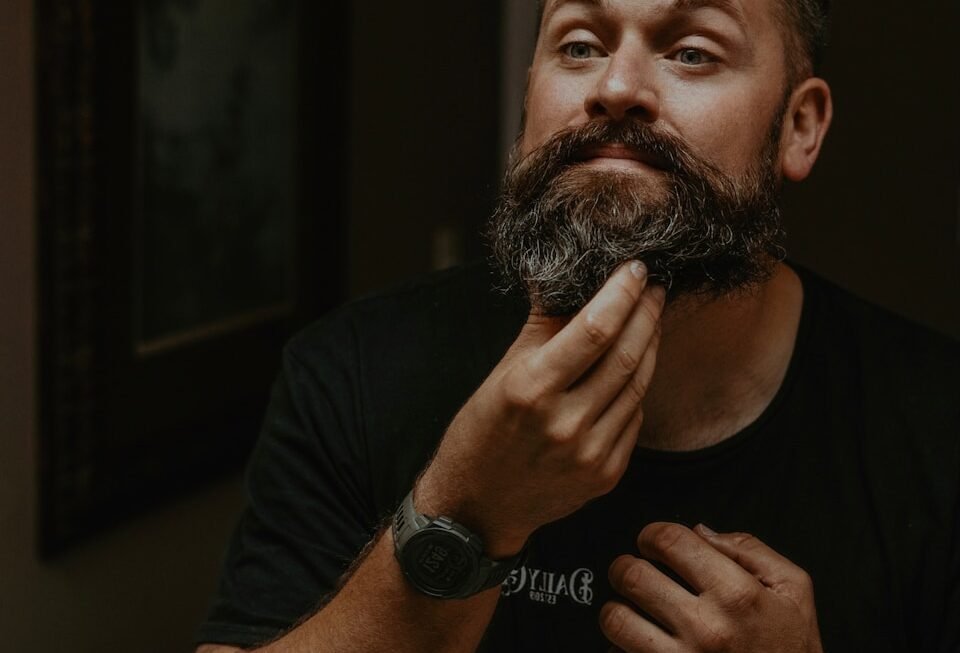 a man is shaving his beard in the mirror